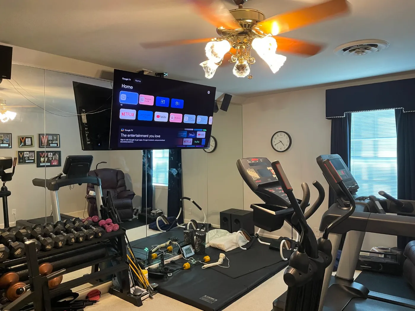 Home gym with TVs set up for every workout by Home Tech Solutions